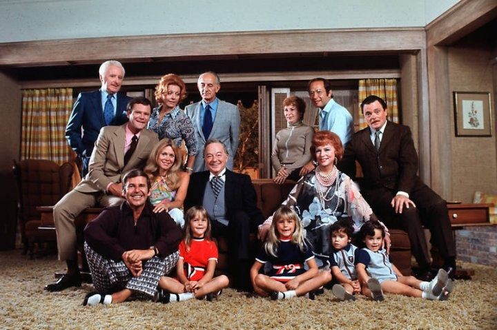 This may contain: a group of people posing for a photo in front of a tv screen with the caption do you know?